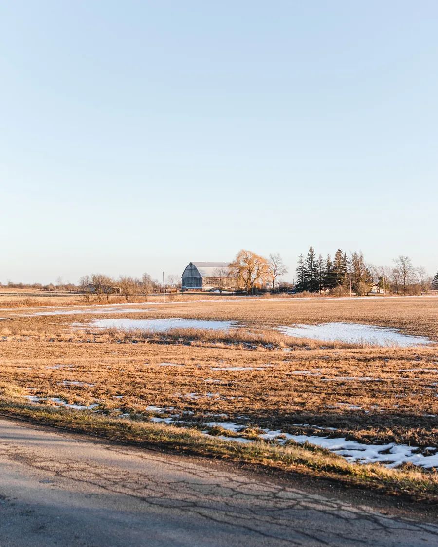 A barn and open fields in the Ontario countryside.
